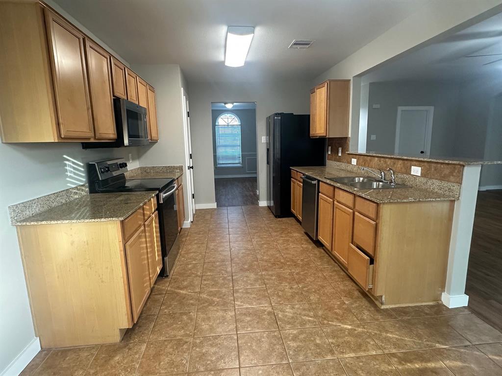 203 Shadow Bend Drive Red Oak, TX 75154 - Photo 8 of 15 a kitchen with stainless steel appliances granite countertop a stove a sink and a microwave