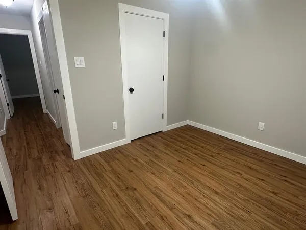 a view of a room with wooden floor and a sink