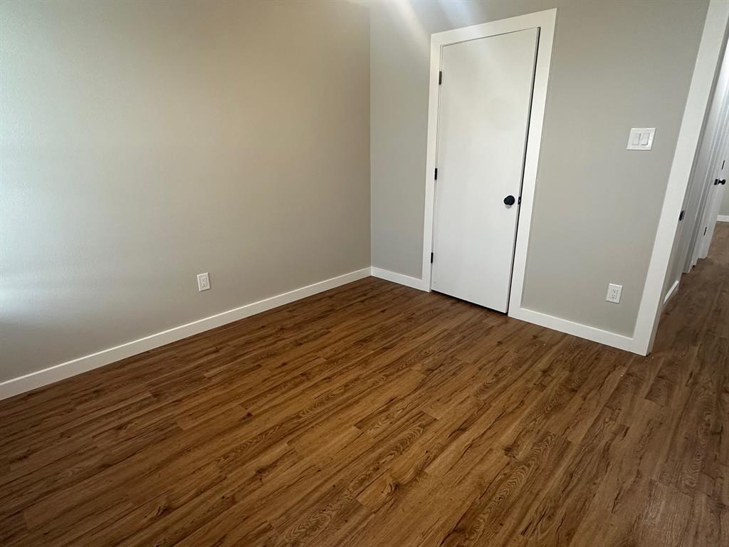 203 Shadow Bend Drive Red Oak, TX 75154 - Photo 10 of 15 a view of an empty room with wooden floor and a window