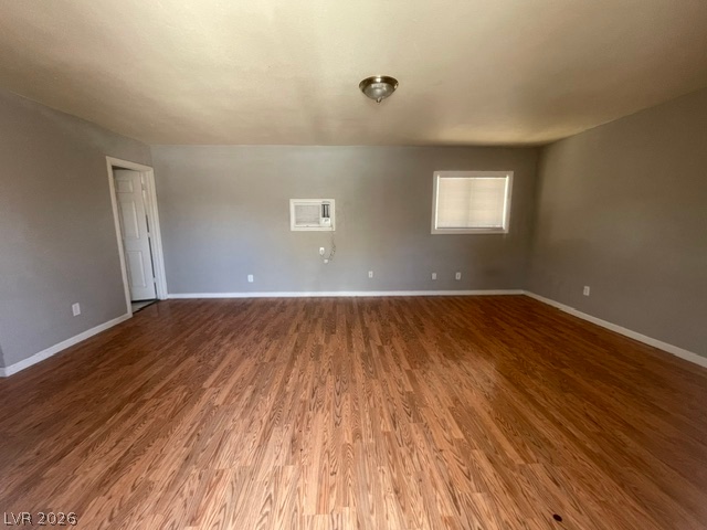 331 South 9th Street, Unit 2 Las Vegas, NV 89101 - Photo 3 of 4 Well-lit living area showcases rich hardwood flooring and convenient wall-mounted air conditioning.