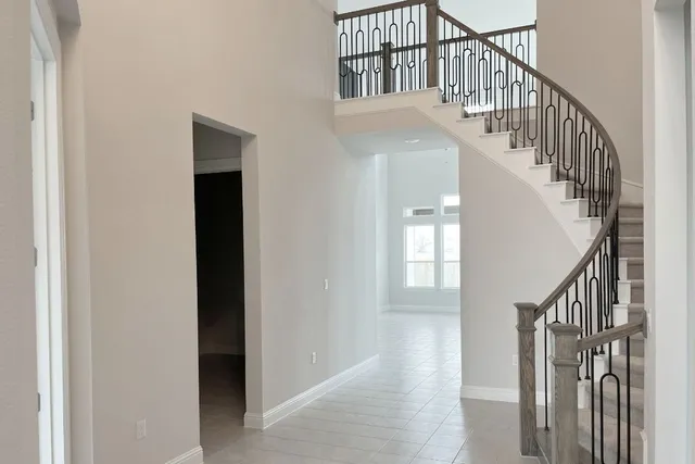 a view of staircase with railing and white walls