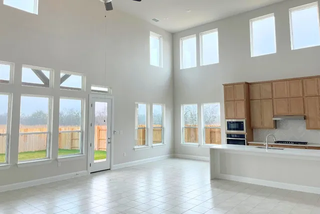 a large white kitchen with granite countertop a large window and a sink