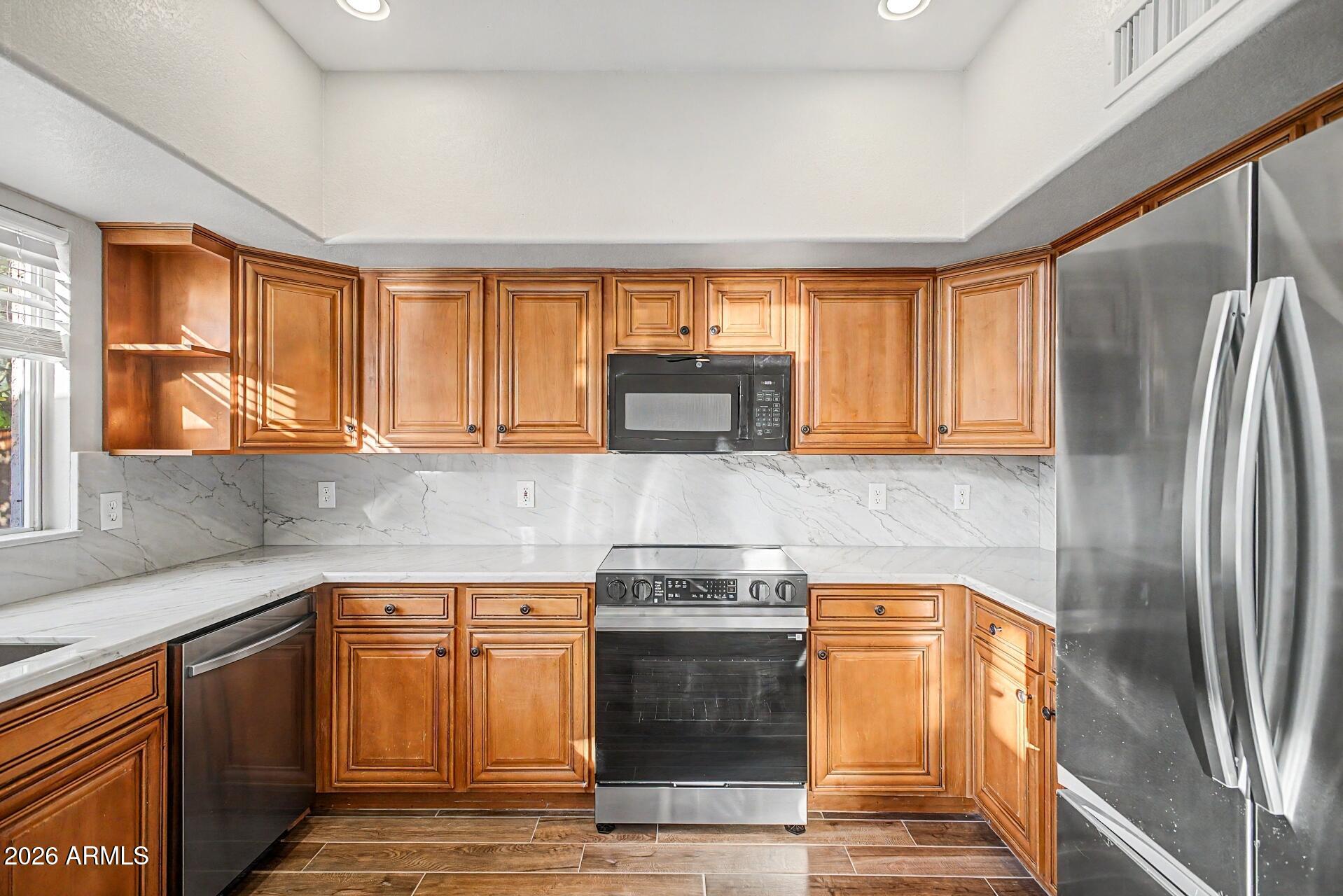 4522 East Rowel Road Phoenix, AZ 85050 - Photo 28 of 61 a kitchen with stainless steel appliances granite countertop a refrigerator a stove and a sink with large window