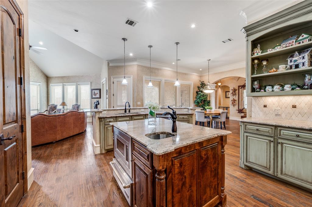 141 Waters Edge Way Oak Point, TX 75068 - Photo 12 of 25 a kitchen with kitchen island granite countertop a sink and a stove top oven