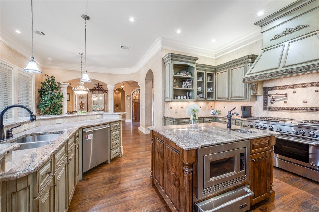 141 Waters Edge Way Oak Point, TX 75068 - Photo 13 of 25 a kitchen with stainless steel appliances granite countertop a stove and a sink