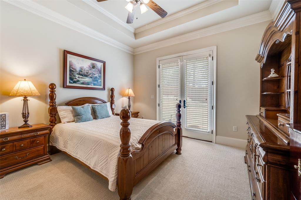141 Waters Edge Way Oak Point, TX 75068 - Photo 19 of 25 a spacious bedroom with a bed and a flat tv screen on dresser