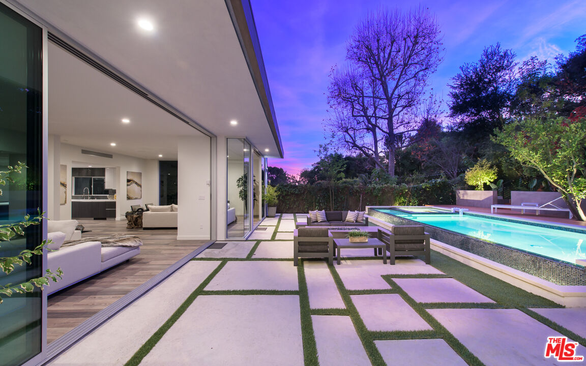2213 Roscomare Road Los Angeles, CA 90077 - Photo 20 of 39 a view of a patio with dining table and chairs with wooden floor and fence