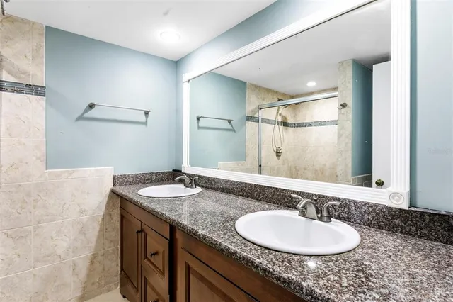 a bathroom with a granite countertop sink and a mirror