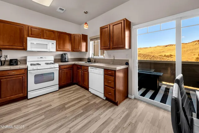 a kitchen with wooden floors appliances and cabinets