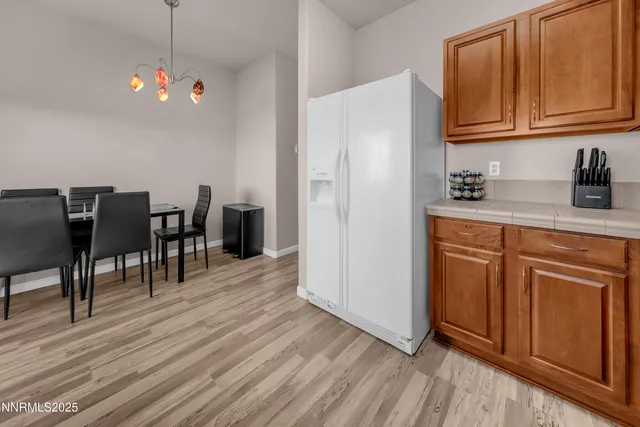 a kitchen with wooden floors and white cabinets