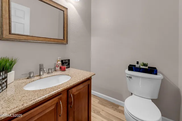 a bathroom with a granite countertop toilet sink and mirror