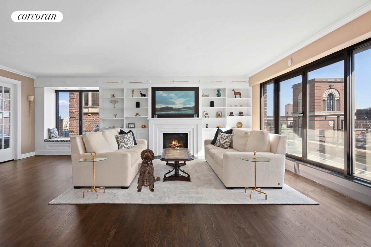 a living room with furniture a large window and a fireplace