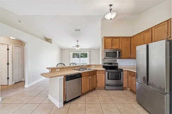 a kitchen with stainless steel appliances granite countertop a sink stove and refrigerator