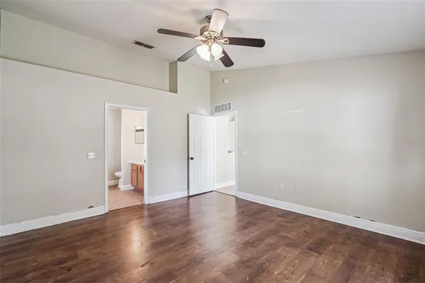 a view of a room with wooden floor and a ceiling fan