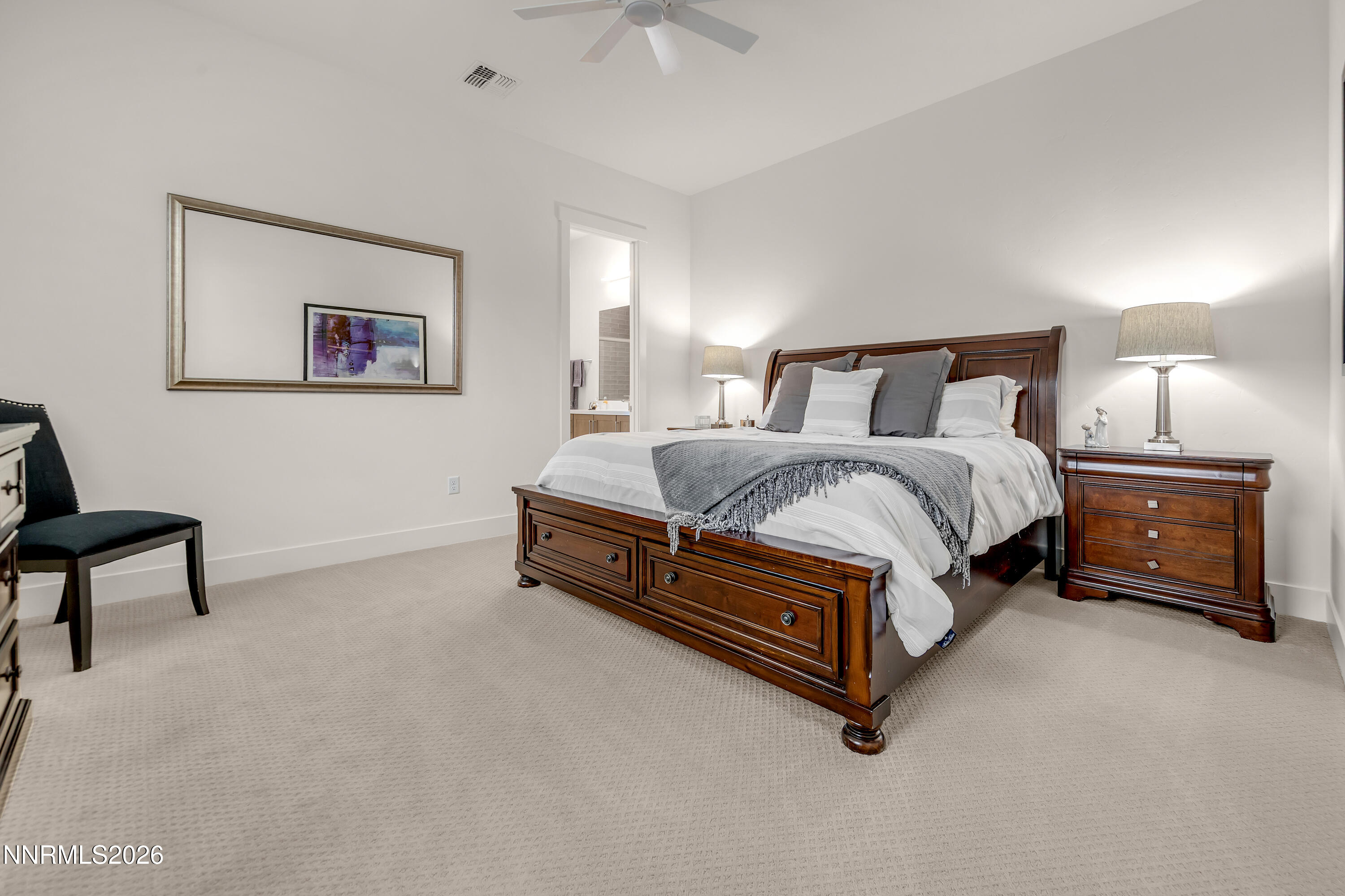 9109 Wild Skies Way Reno, NV 89523 - Photo 31 of 81 a spacious bedroom with a bed and a lamp on a dresser