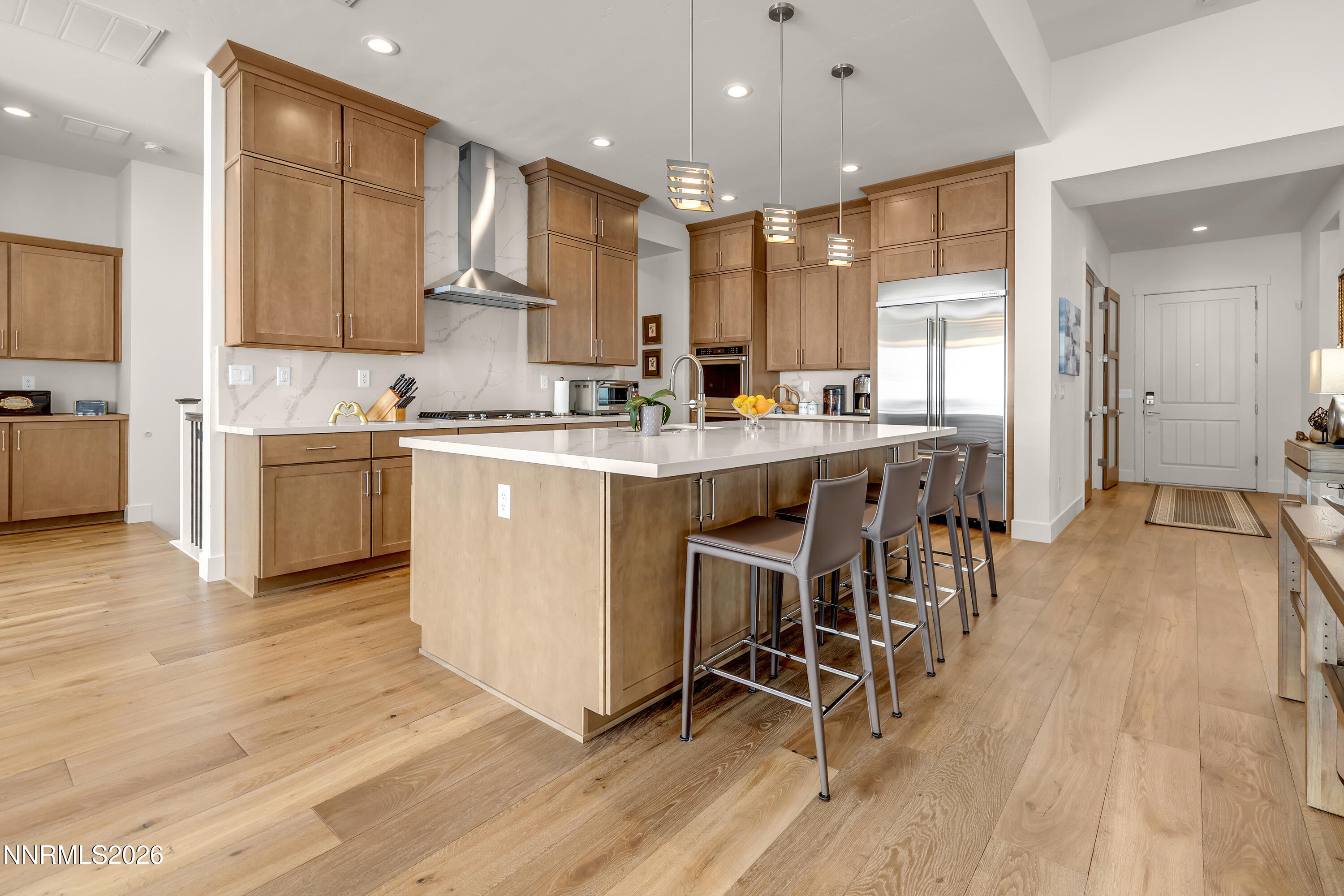 9109 Wild Skies Way Reno, NV 89523 - Photo 8 of 81 a kitchen with stainless steel appliances kitchen island granite countertop a table chairs sink and cabinets