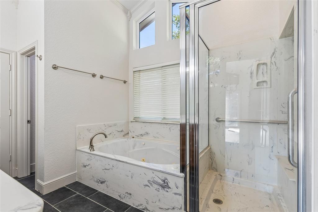 1155 Point Vista Road Hickory Creek, TX 75065 - Photo 22 of 40 Soaking tub with a polished nickel faucet, glass-enclosed shower with a built-in bench, and high transom windows