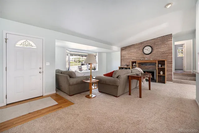 a living room with furniture a fireplace and a window