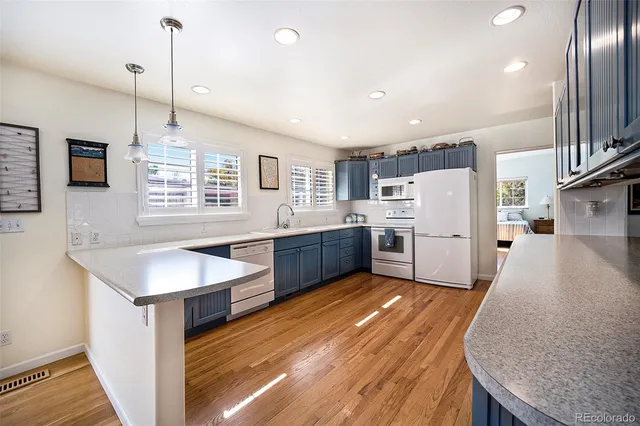 a kitchen with white cabinets and white appliances