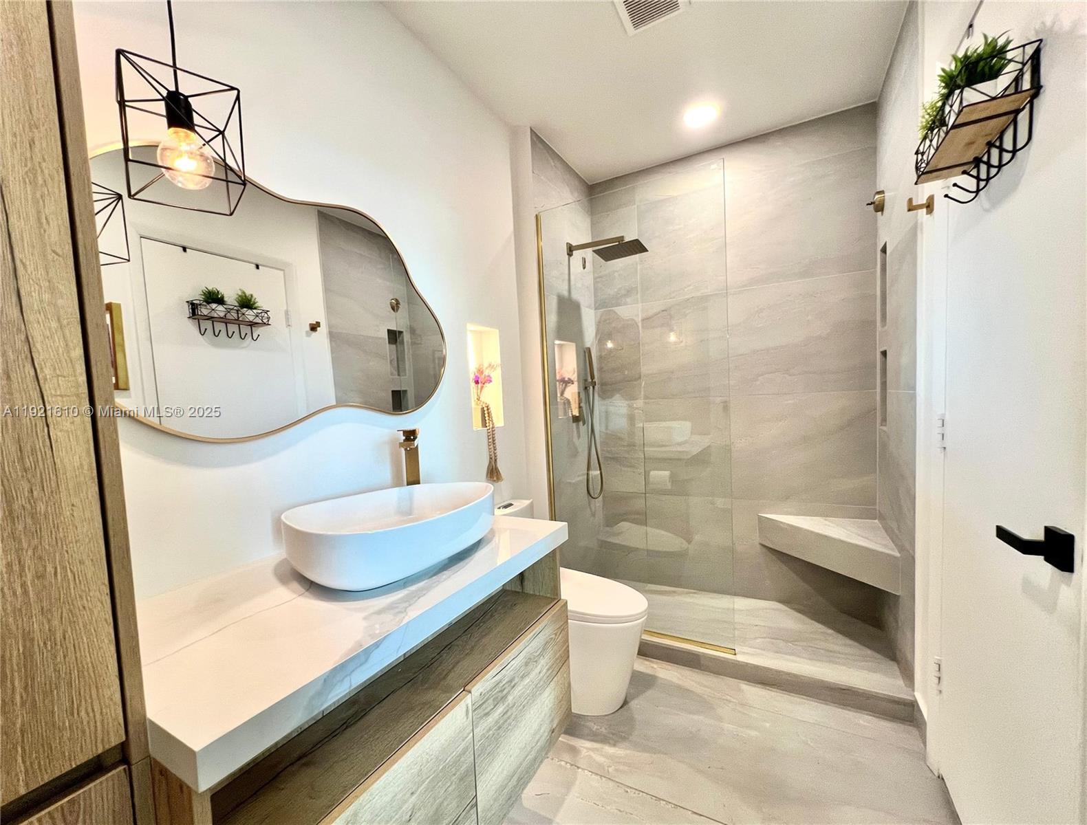 1900 North Bayshore Drive, Unit 909 Miami, FL 33132 - Photo 16 of 23 a bathroom with a granite countertop sink a toilet and shower