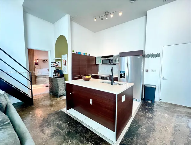 a view of kitchen with stainless steel appliances granite countertop a stove and a refrigerator