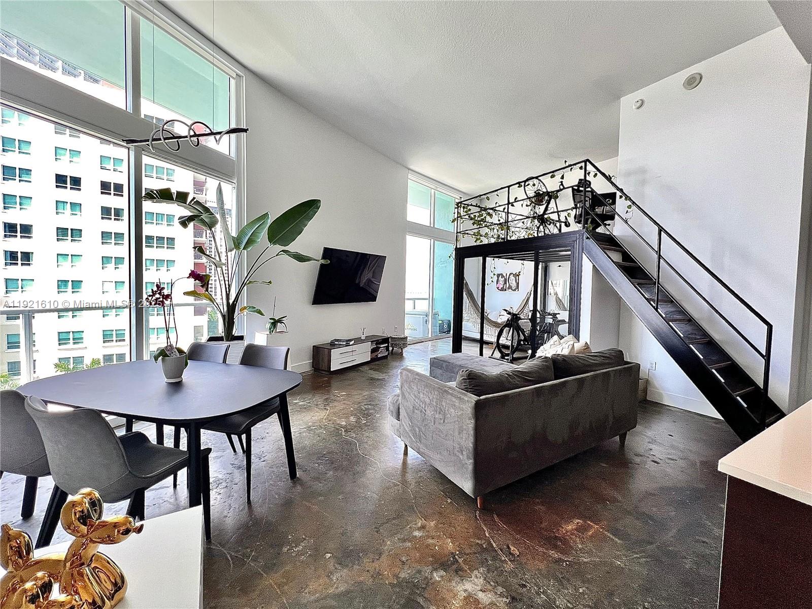 1900 North Bayshore Drive, Unit 909 Miami, FL 33132 - Photo 4 of 23 a living room with furniture and a flat screen tv