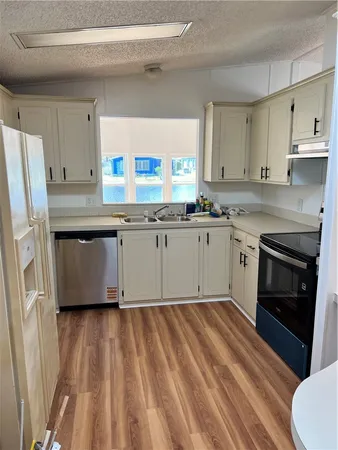 a kitchen with granite countertop a sink stainless steel appliances and cabinets