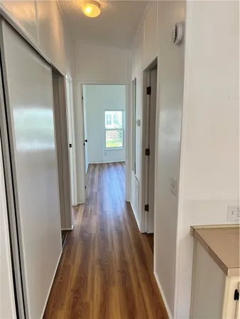 a view of a hallway with wooden floor