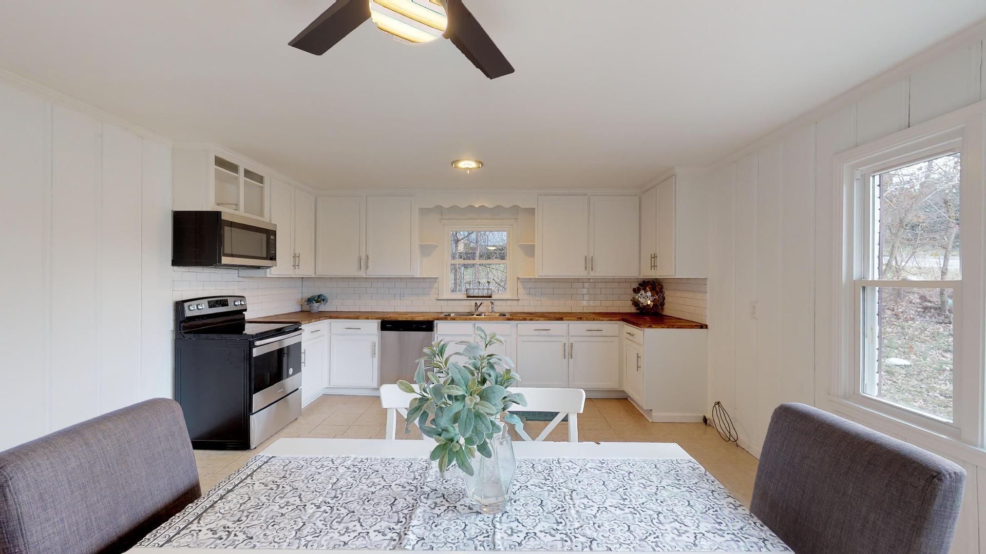 3064 Anderson Road Nashville, TN 37217 - Photo 12 of 29 a kitchen with white cabinets and black appliances