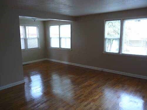8001 Densmore Avenue North Seattle, WA 98103 - Photo 16 of 22 a view of an empty room with wooden floor and a window
