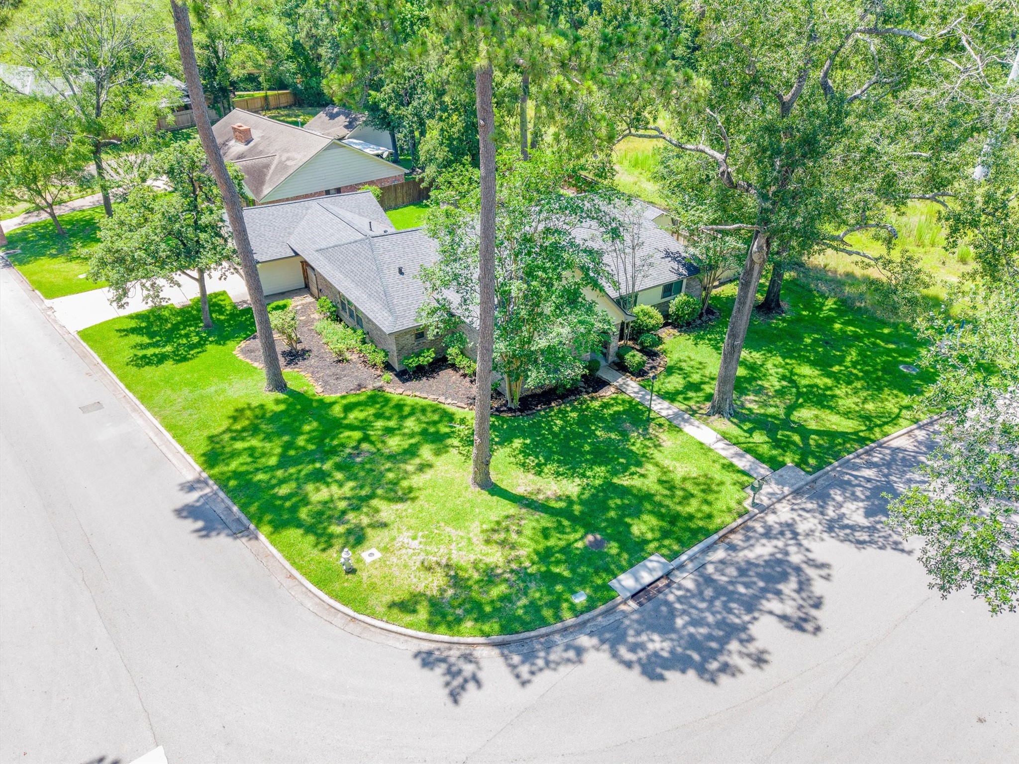 826 North Rivershire Drive Conroe, TX 77304 - Photo 39 of 46 From above, the corner lot positioning and mature tree canopy tell the full story of what makes this property special. The lot wraps generously at the corner and the trees provide natural privacy that takes decades to grow.