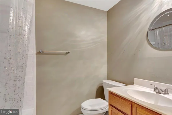 a bathroom with a granite countertop toilet sink and a mirror