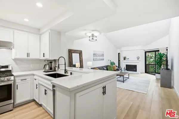 a kitchen with stainless steel appliances granite countertop a refrigerator sink and stove