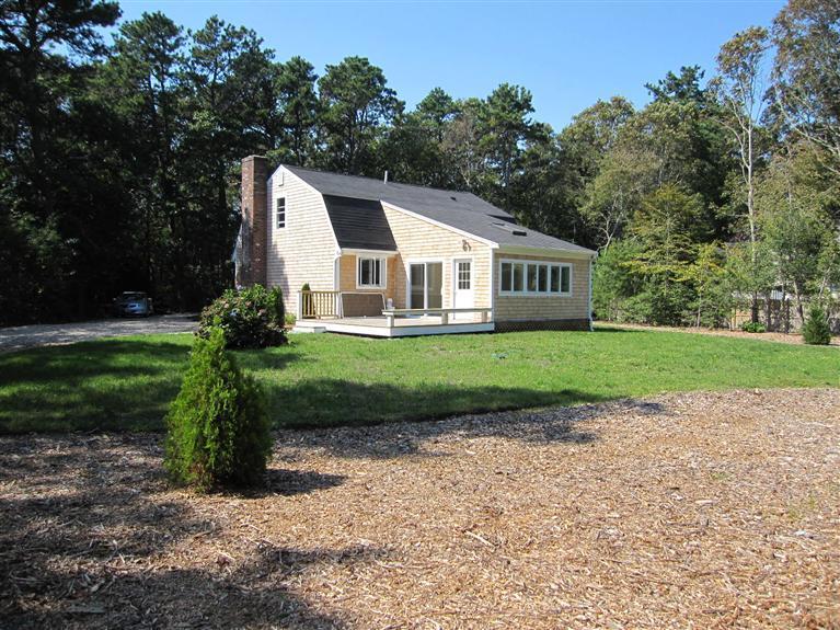 560 Skunknet Road Centerville, MA 02632 - Photo 3 of 24 a front view of a house with a yard and garage