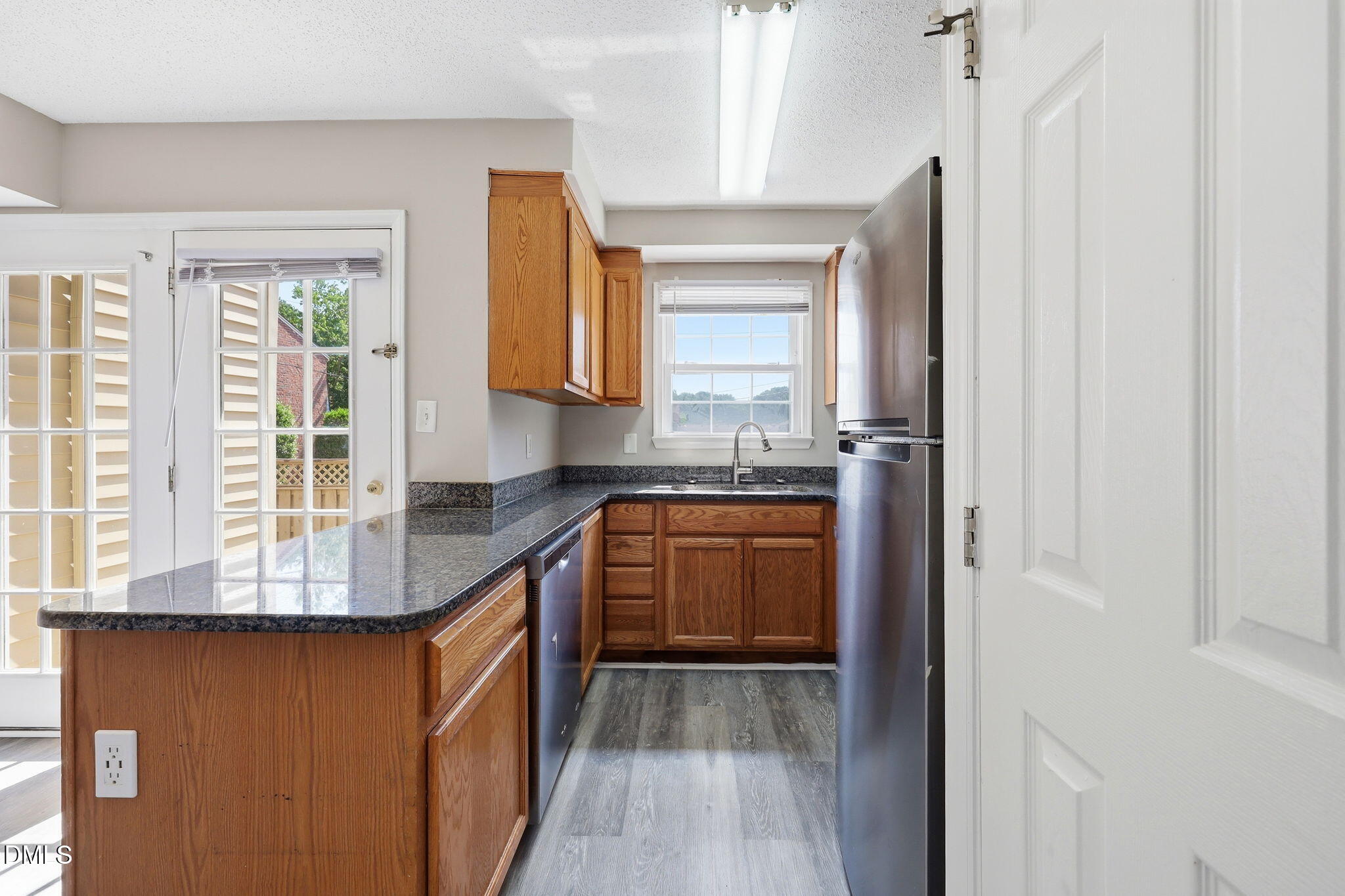 145 Jones Franklin Road, Unit D Raleigh, NC 27606 - Photo 6 of 23 a kitchen with kitchen island granite countertop a sink and a stove top oven