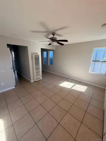 a view of a livingroom with a chandelier fan and windows