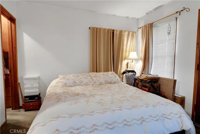 a bedroom with a bed and a large window