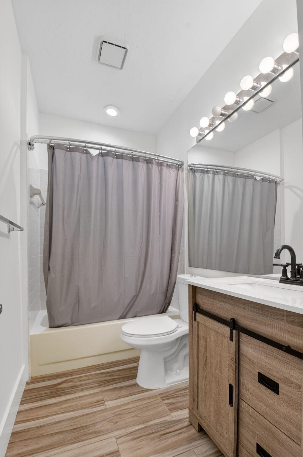 2225 Northwest 53rd Street Boca Raton, FL 33496 - Photo 22 of 46 a bathroom with a sink a toilet a mirror and shower curtain