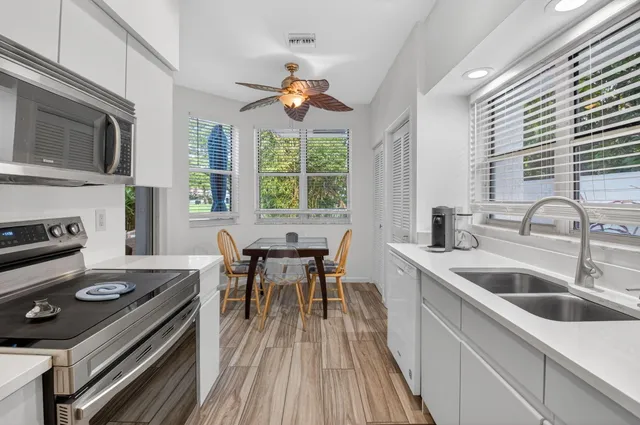 a kitchen with a stove a sink and wooden floor