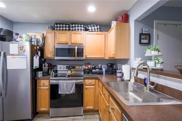 a kitchen with stainless steel appliances granite countertop a sink stove and refrigerator