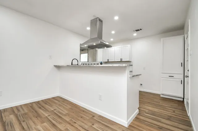 a kitchen with stainless steel appliances granite countertop a sink cabinets and wooden floor