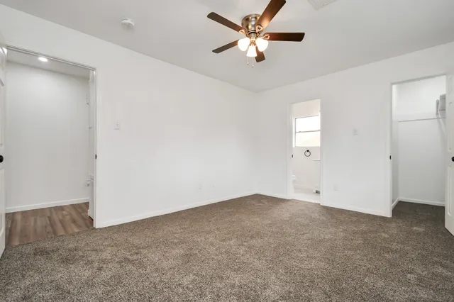 an empty room with a ceiling fan and a window