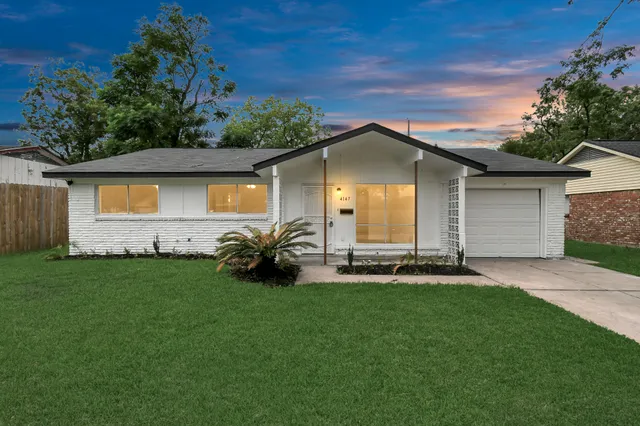 a front view of a house with a garden and yard