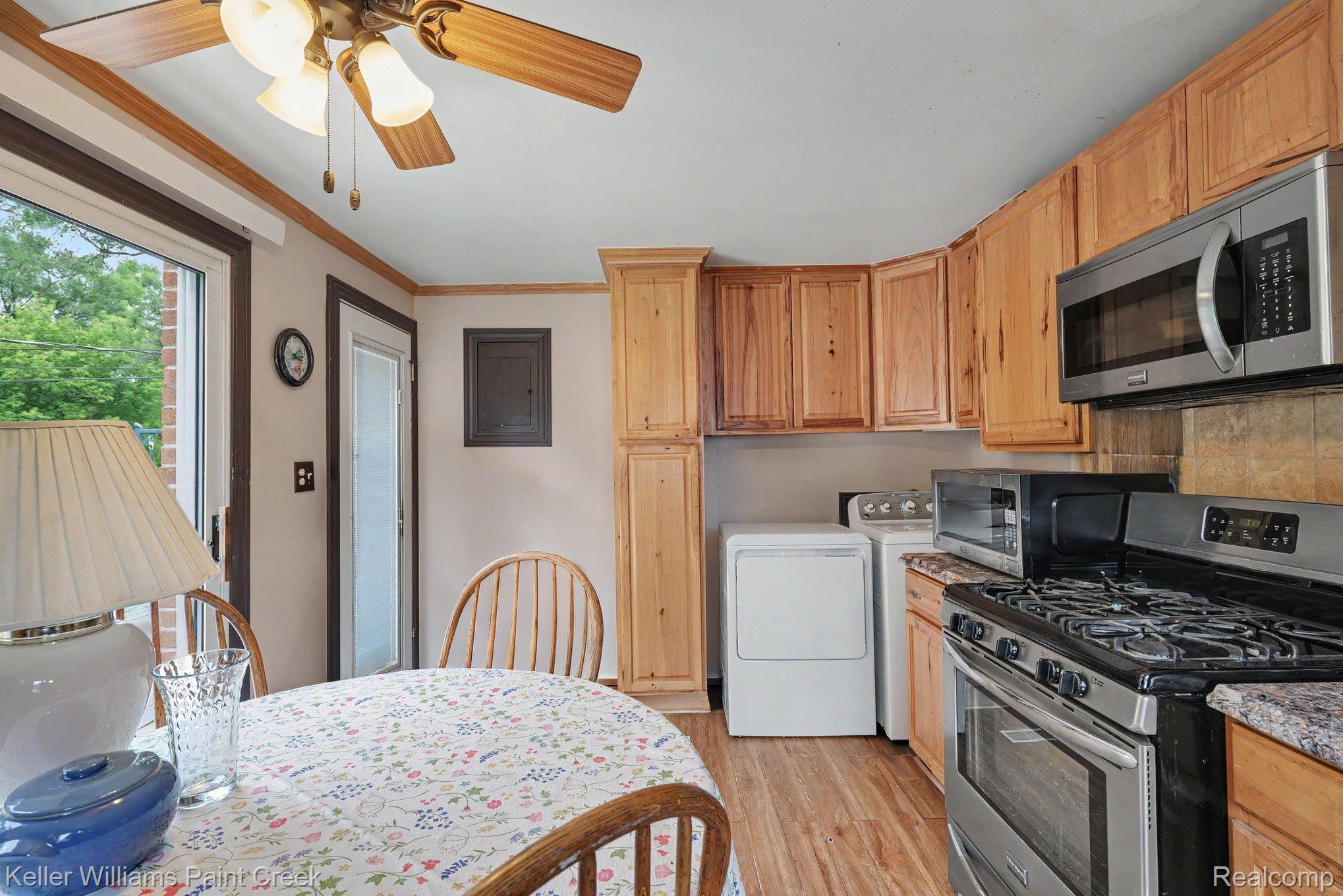 2340 Hessel Avenue Rochester, MI 48307 - Photo 9 of 25 Kitchen featuring warm wood cabinetry, stainless steel appliances including a gas range and built-in microwave, wood-finish flooring, and a ceiling fan