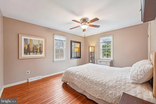 a view of a livingroom with wooden floor and a ceiling fan