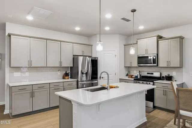 a kitchen with counter top space sink stainless steel appliances and cabinets