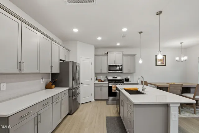 a kitchen with a sink a stove a refrigerator and cabinets