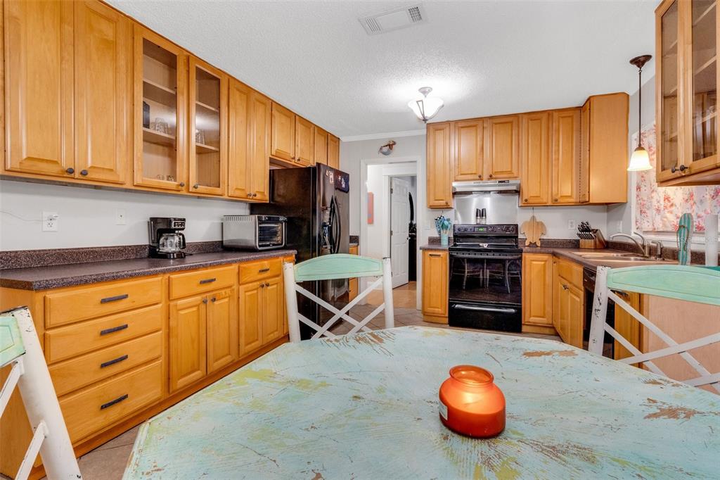 202 St Lucie Road Winter Haven, FL 33884 - Photo 7 of 32 a kitchen with stainless steel appliances kitchen island granite countertop a stove a sink and a refrigerator