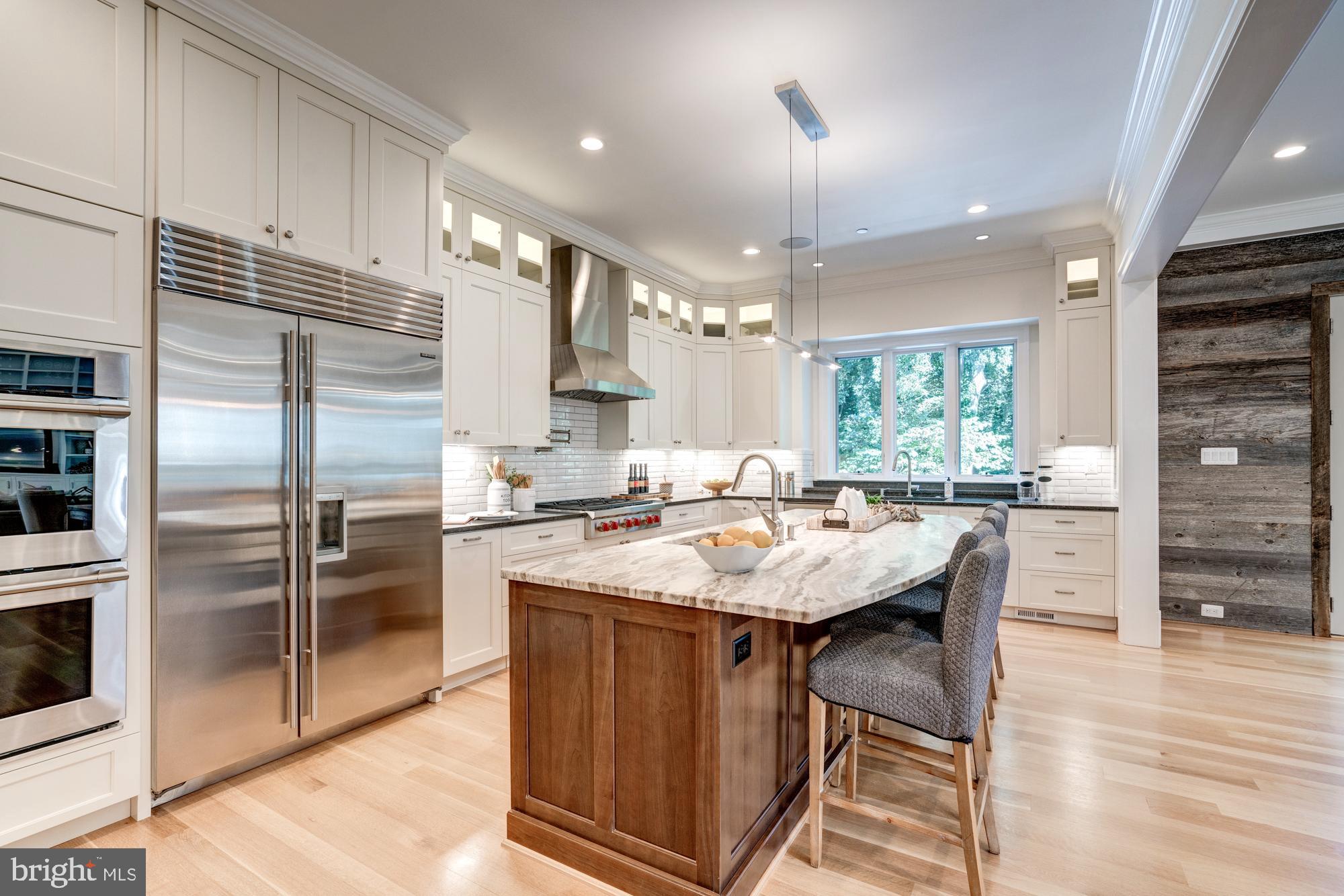 5607 Warwick Place Chevy Chase, MD 20815 - Photo 15 of 91 a kitchen with stainless steel appliances kitchen island granite countertop a table chairs and a refrigerator