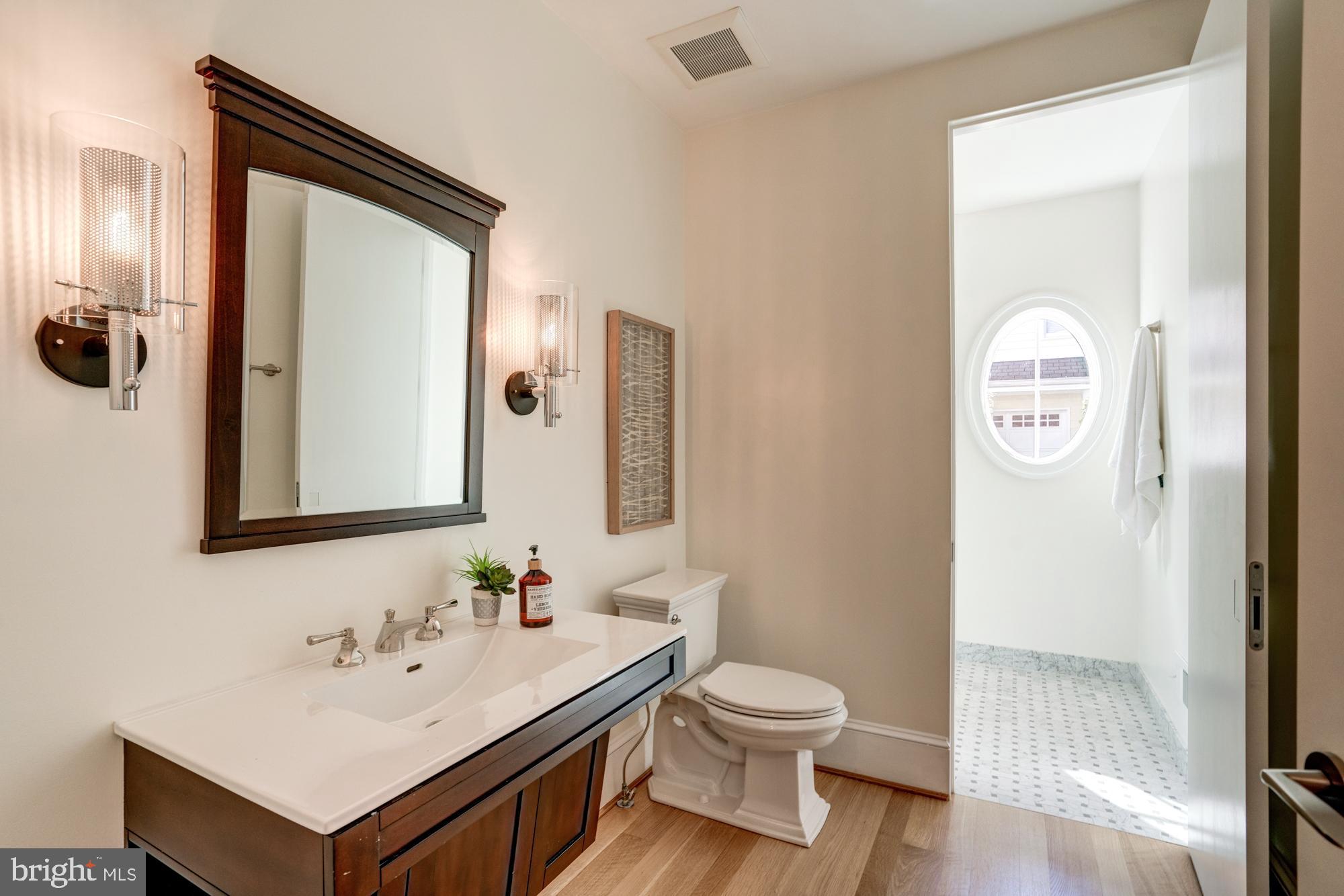 5607 Warwick Place Chevy Chase, MD 20815 - Photo 39 of 91 a bathroom with a toilet sink and mirror